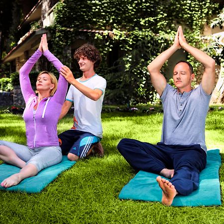 马蒂美亚酒店 特基罗瓦 外观 照片 A yoga teacher assists students with their practice.
