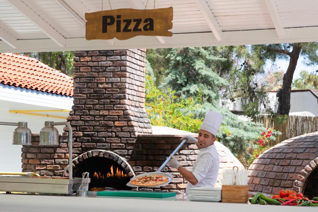 马蒂美亚酒店 特基罗瓦 外观 照片 Pizza being prepared in a wood-fired oven